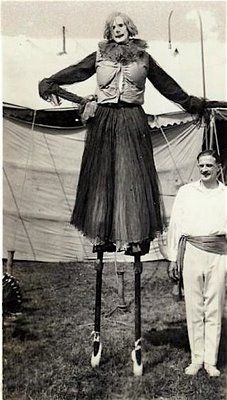 a woman standing next to a mannequin on top of a grass covered field