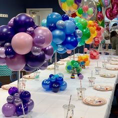 the table is set with many balloons and plates