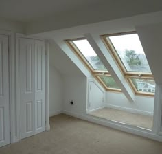 an empty room with two skylights in it