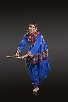 a figurine of a man dressed in blue is holding a stick with both hands