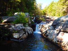 there is a small waterfall in the middle of some rocks