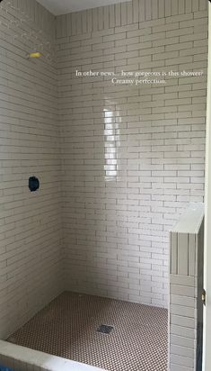 an empty shower stall in a bathroom with tile flooring and walls that have been painted white