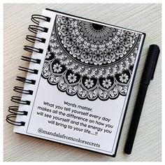 a spiral notebook with an inspirational quote on the cover and a pen next to it