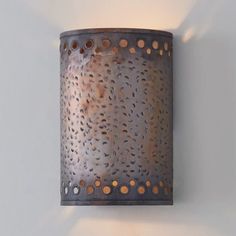 a wall light that is on the side of a wall with holes and circles in it