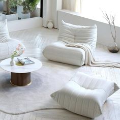 a living room filled with white furniture and pillows