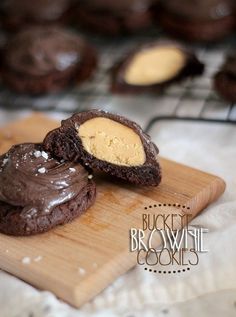 chocolate cookies with peanut butter in the middle on a cutting board