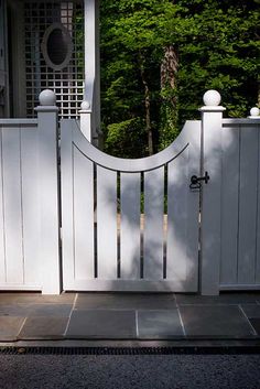 a white gate with a circular mirror on it's top and door handle at the bottom