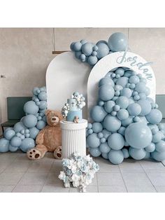 there is a teddy bear and balloon arch in the middle of this room with balloons all around it