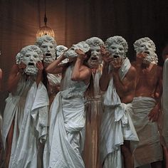 a group of people with white masks on their faces standing in front of each other