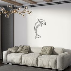 a living room with a white couch and a dolphin wall decal on the wall