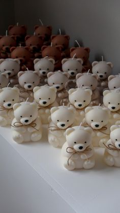 there are many small teddy bears sitting on the table with string attached to their ears