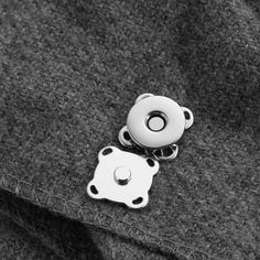 a black and white photo of a button on a jacket with two other buttons attached to it