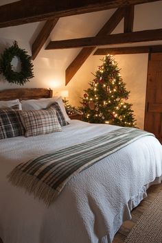 a bedroom with a christmas tree in the corner and pillows on the bed next to it