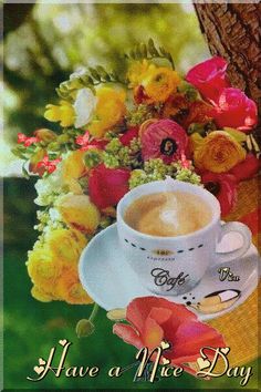 a cup of coffee sitting on top of a saucer next to a bouquet of flowers