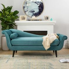 a blue couch sitting in front of a fire place next to a potted plant