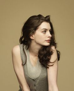 a woman with long brown hair sitting down