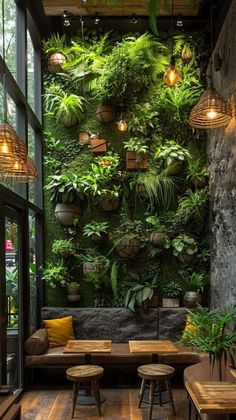 a living room filled with lots of plants on the wall and wooden tables in front of it