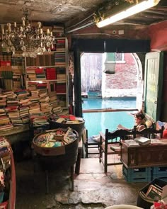 a room filled with lots of books next to a pool