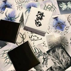 many different designs are shown on this table top with black and white papers in the middle