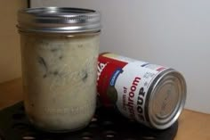 a jar of food sitting on top of a table next to a can of soda