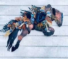 a horse made out of paper and flowers on the side of a building with white walls