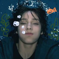 a young man with his eyes closed in front of an image of fish and bubbles