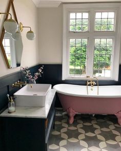 the bathroom is decorated in black and white with an antique claw foot bathtub, tile floor