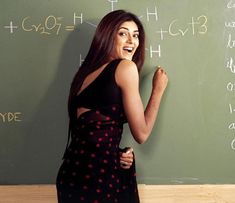 a woman standing in front of a blackboard