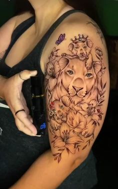 a woman's arm with a lion and flowers tattoo on the side of her body