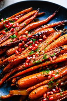 roasted carrots with pomegranate and parsley on a blue platter