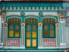 an old building with green and yellow windows