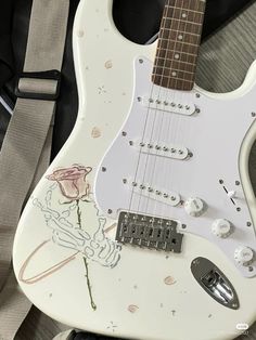 an electric guitar with a rose painted on it