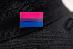 a pink, blue and purple striped lapel on a black hat with holes in it