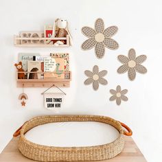 a wicker bassinet on a wooden table in front of white wall with flower cutouts