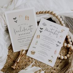 the wedding stationery is laid out on a wicker basket with beads and tassels