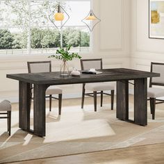 a dining room table with chairs and a vase on the table in front of it