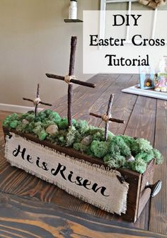 a wooden box filled with moss and three crosses