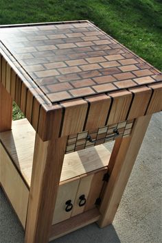 a wooden table with drawers on it in the middle of a yard and grass behind it