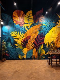 a large mural in the middle of a room with wooden floors and chairs around it