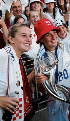 the women's soccer team is posing for a photo with their trophy and fans