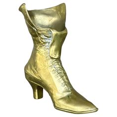 a gold shoe that is on top of a white surface