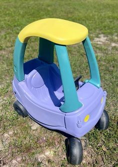 a plastic toy car sitting on top of a grass covered field