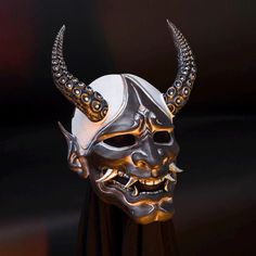 a metal mask with horns and spikes on it's head is shown in front of a black background