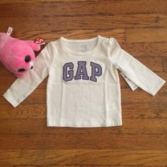 White Long-Sleeved Tee Shirt With Gap Logo In Lavender (Outlined In Purple). 100% Cotton. Cotton Tops With Letter Print For Playtime, Cotton Tops With Letter Print For Playwear, Spring Tops With Letter Print For Playtime, Cute White Tops For Fall, Casual Purple Top For Playtime, Cute Gap Cotton T-shirt, Gap Long Sleeve Top With Letter Print, Cotton T-shirt For Playwear In Fall, Fall Playtime Tops With Short Sleeves