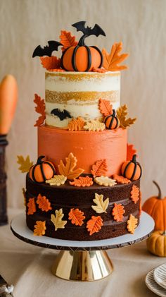 a multi layer cake decorated with pumpkins and leaves