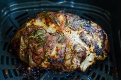 grilled meat with herbs on top in an air fryer basket, closeup