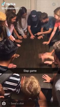 several people sitting around a table with their hands on each other's shoulders and the caption says slap game send a chat