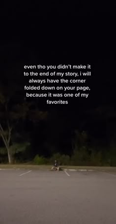 an empty parking lot at night with a person on a motorcycle