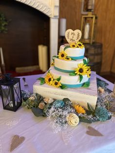 a three tiered cake with sunflowers on top