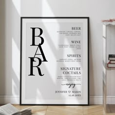 a framed poster with the words bar in black and white, on a wooden floor